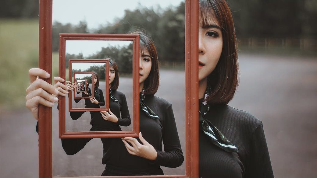 young woman with multiple reflection in mirror